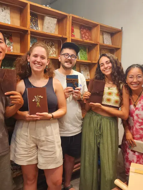 A group holds the notebooks they made in the bookbinding workshop